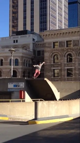 Skater riding a ledge in front of historic buildings in downtown Denver