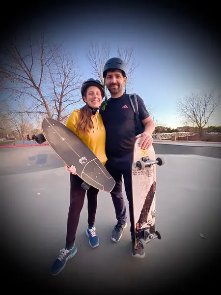 Couple smiling with cruiser skateboards after a skateboard lesson in Colorado